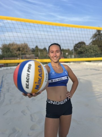 Denisa extending a volleyball towards the camera