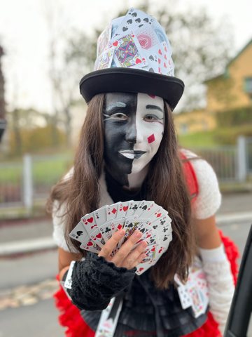 Denisa in a costume with face paint and playing cards