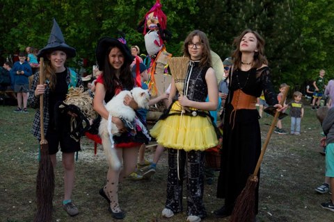 Costumed participants with brooms at an outdoor community event