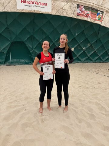 Volleyball teammates displaying tournament certificates