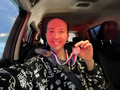 Denisa holding a medal after a tournament