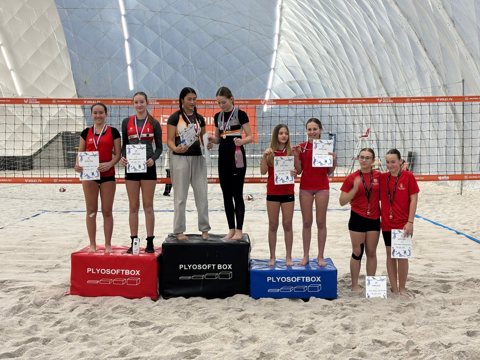 Beach volleyball players at an indoor tournament awards ceremony