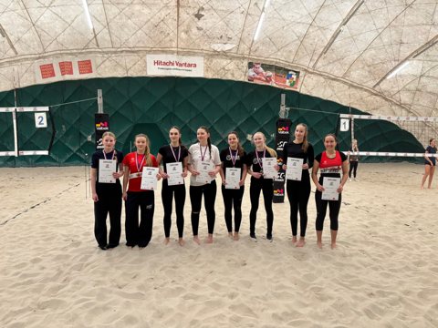 Beach volleyball players at an indoor tournament awards ceremony