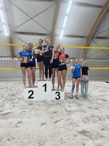 Beach volleyball players at an indoor tournament awards ceremony